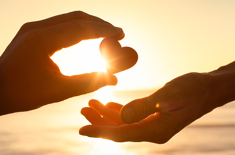 Hand giving heart-shaped object